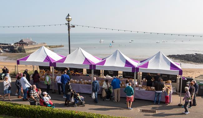 Group of purple and white covered stalls on Broadstairs seafront selling food and drink