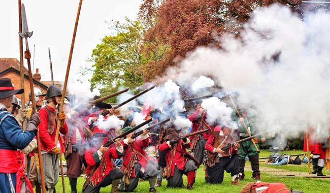 reenactors holding muskets