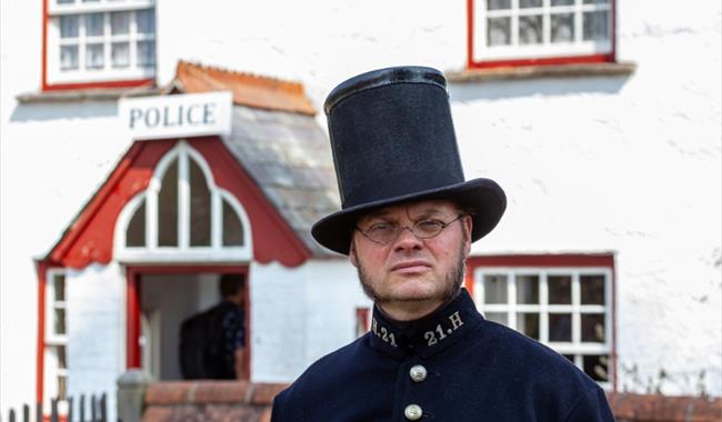 man dressed as victorian police man outside police station