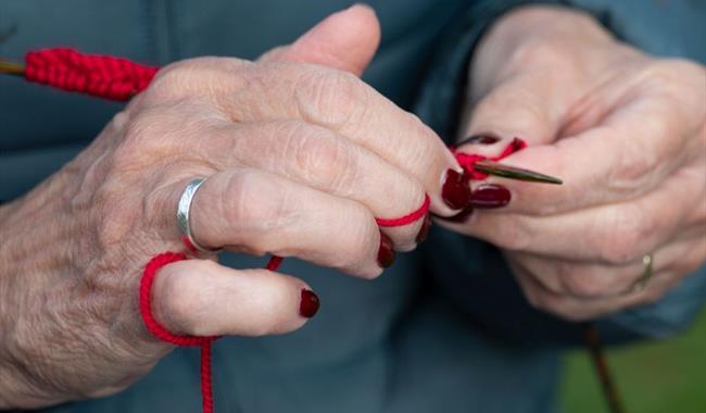 A close up of a lady knitting