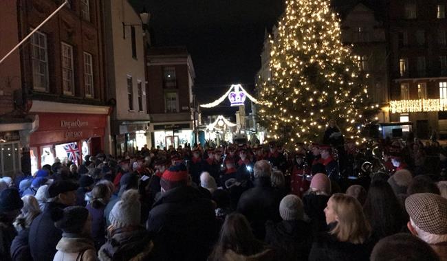 Carols on the Hill - crowd singing around the Christmas tree and with military band, Christmas lights in background
