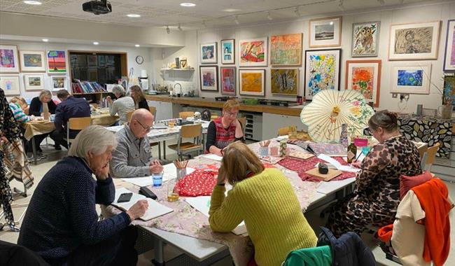A group of people drawing in the studio during a drink and draw workshop