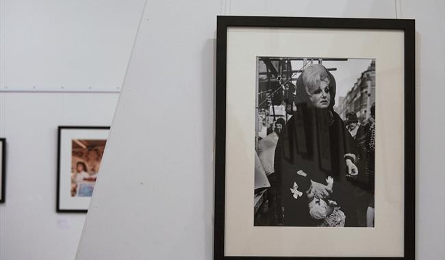 exhibition install photograph showing a wall of framed black and white photographs