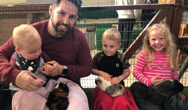 Family handling guinea pigs