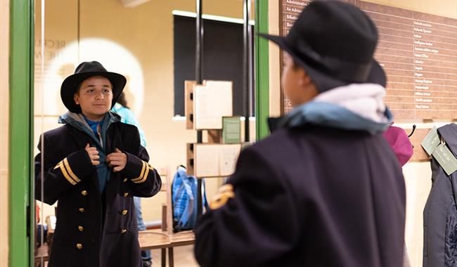 A boy dressing up in uniform at Bletchley Park