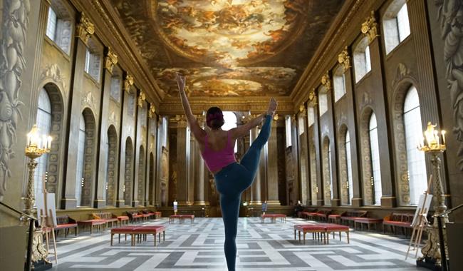 Woman doing a yoga pose in the Painted Hall.