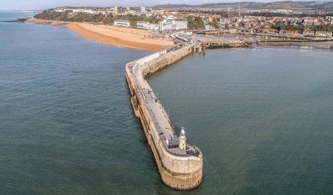 View over Folkestone harbour arm with town in the distance