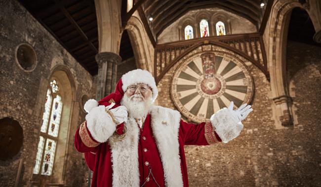 Father Christmas with The Great Hall and Round Table in the background.