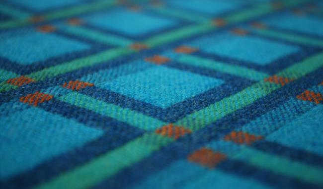 image of one of the fabrics in the exhibition which is blue, green and red design woven in wool