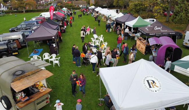 Farmers Market from Birds eye view. Gazebos, people gathering with food.