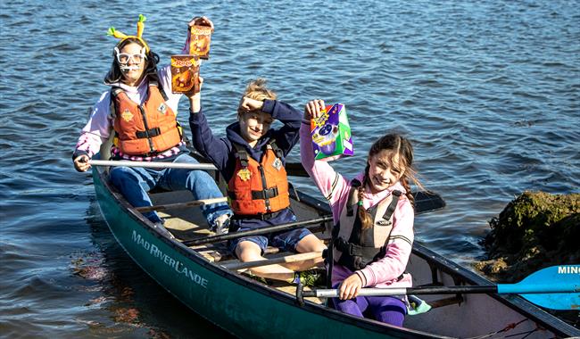 Children in a canoe holding easter eggs