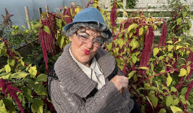 Effel Fartwaffer crouched down between some purple coloured plants