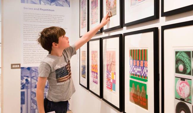 Child pointing at framed artwork on gallery wall