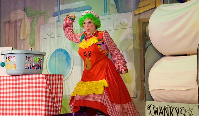 Cast member dressed in Dame costume