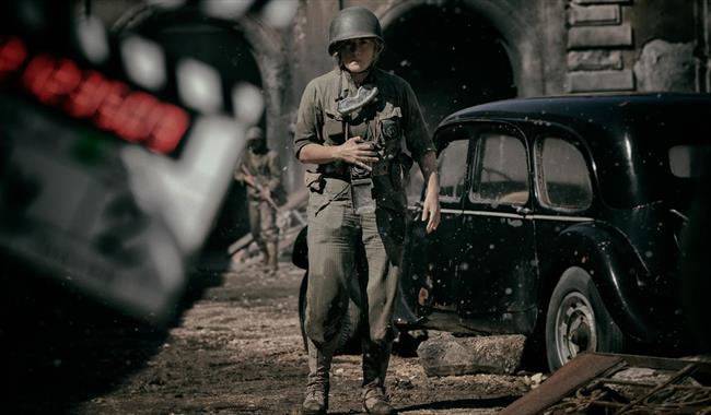 Colour photograph of a film set showing Kate Winslet as Lee Miller, dressed in army uniform in the 1940s