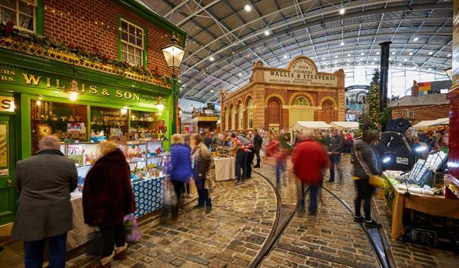 People walking around a museum at a Christmas market