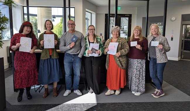 A group of people looking happy with their work on completion of a workshop