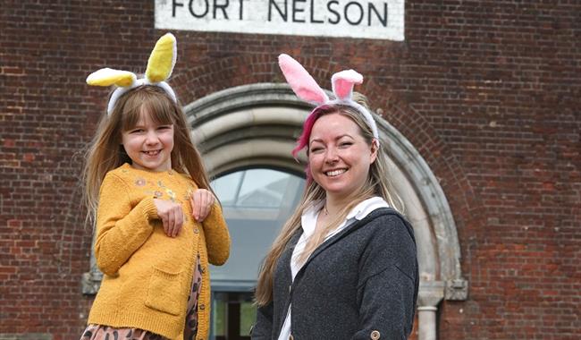 A woman and child, both wearing Easter bunny ears, stood outside the entrance to Fort Nelson