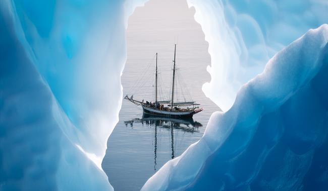 A yacht on the water through a hole in the ice
