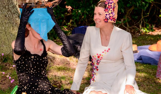 Contemporary photograph of two women in fancy dress costume having a picnic