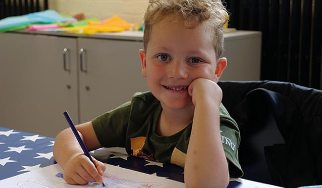 A child smiles at the camera enjoying the family activities at Bletchley Park