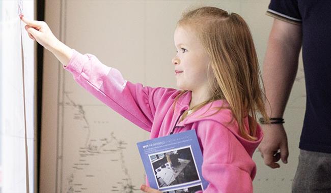 A girl enjoying playing with an interactive screen in an exhibition at Bletchley Park