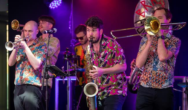 Image: The Concertini with Brass Monkeys performing on stage with brass instruments