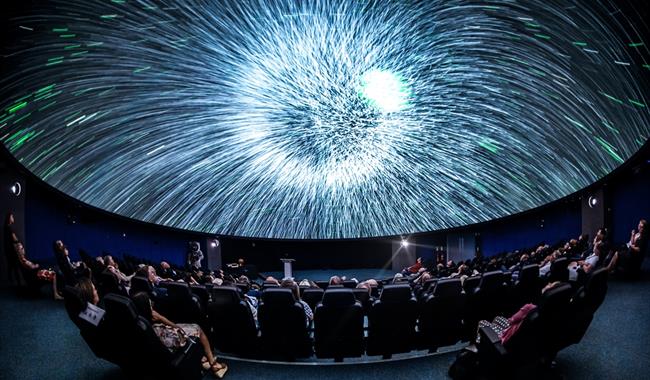 A photo inside the Planetarium. Bright light on the screen.