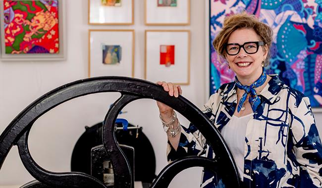 Tori McLean standing by her Rochet etching press at Studio 21