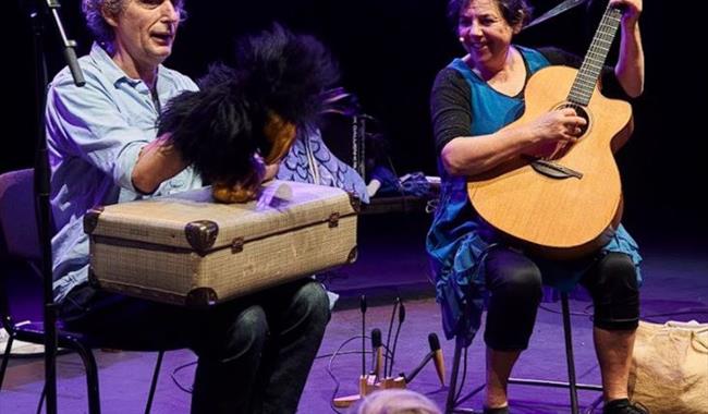 Image: Two musicians on stage with their guitar and puppets