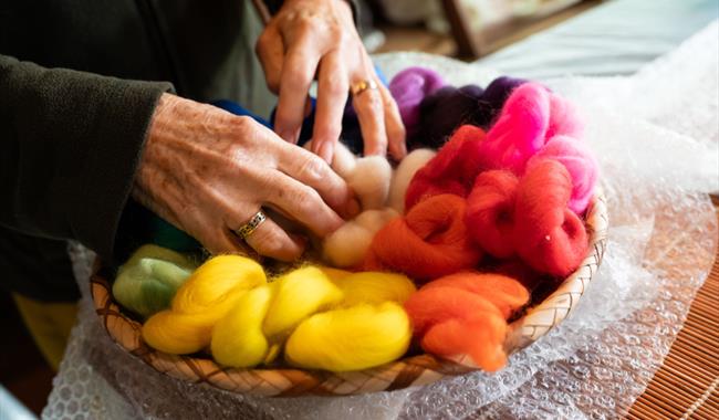 hands in multi-coloured wool