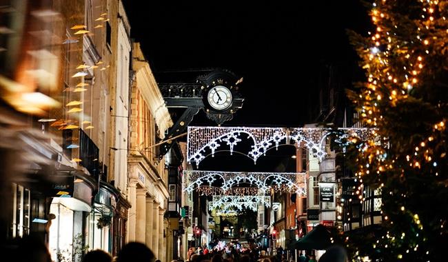 Winchester high street at night with Christmas lights and a Christmas tree.