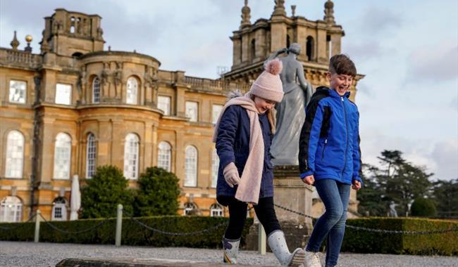 Two children walking in front of Blenheim Palace