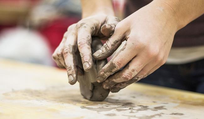 Child's hands playing with block of clay