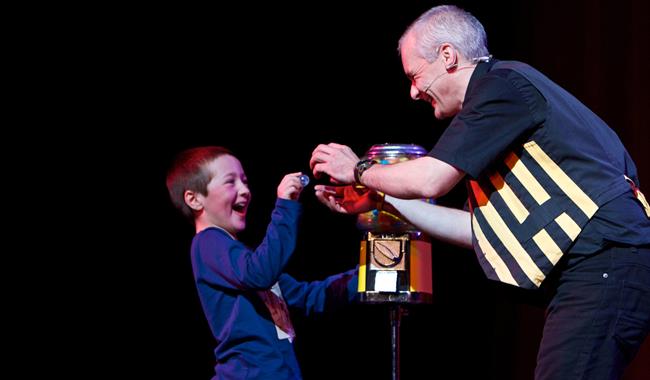 A magician showing a child a ball