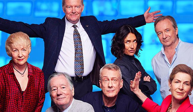 Against a light blue background is an array of famous faces: Robert Duncan stands at the back with both arms stretched out wide in a dark blue suit, w