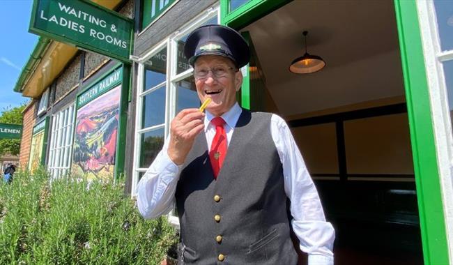 Conductor eating a chip at the Fish and Chip Evenings at Isle of Wight Steam Railway, Wootton, summer event