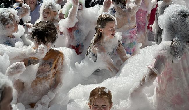 Children dancing in foam for foam party