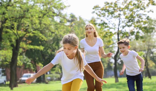 Two children and an adult playing an outdoors game