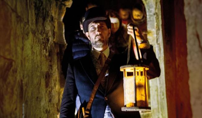 Man with a lantern exploring Carisbrooke Castle in the dark, Halloween event, what's on, Isle of Wight