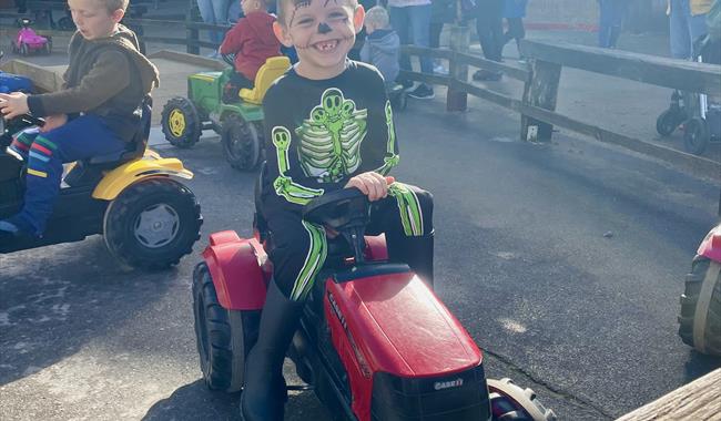 Child on Pedal Tractors during Halloween