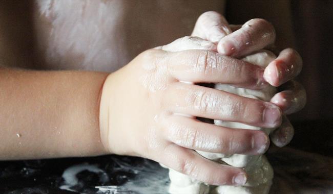 Child's hands playing with clay