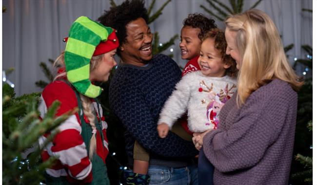 Family laughing surrounded by Christmas trees at Odds Farm Park