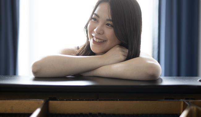 Image: Sherri Lun standing over piano