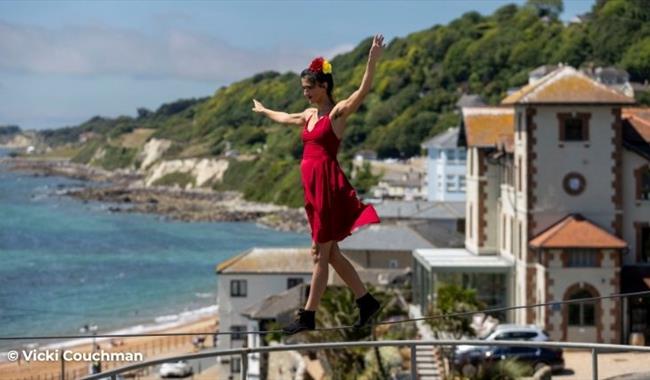 Lady walking along a tightrope with the sea in the background in Ventnor on the Isle of Wight