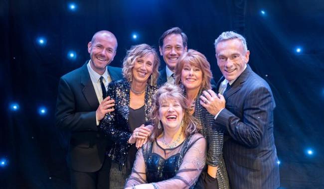 6 people in front of a glittery background