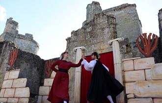 medieval style actors in the grounds of a castle.