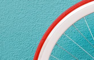 Bicycle wheel against a bright wall