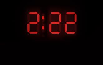 The numbers 2.22 are displayed in a large red font, like that of a digital clock display. In smaller capital white letters underneath reads: 'A Ghost