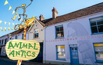 A photograph of the outside of the Roald Dahl Museum during a snow storm, with Mother Christmas carrying presents